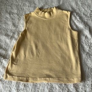 A pastel Yellow crew neck sleeveless top.